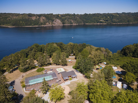Vue aérienne du parc de vacances Huttopia Lac de la Siauve en Auvergne-Rhône-Alpes, forêt, piscine et lac.