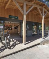 Entrada de Huttopia Lac de la Siauve con porche de madera, bicicletas de alquiler y recepción en Auvergne-Rhône-Alpes.