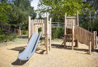 Speeltuin met houten glijbaan en klimrek bij Huttopia Lac de la Siauve, Auvergne-Rhône-Alpes, Frankrijk.