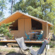 Safari telt Toile&bois Classic på en skovcampingplads med terrasse og udendørs siddepladser i naturen.