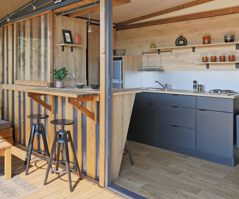 Contemporary kitchenette and bar inside Arizona safari tent at Huttopia Vallée du Lot in France.