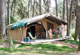 Familia disfruta en la tienda safari Sweet de Huttopia Divonne Les Bains, rodeada de bosques en Francia.