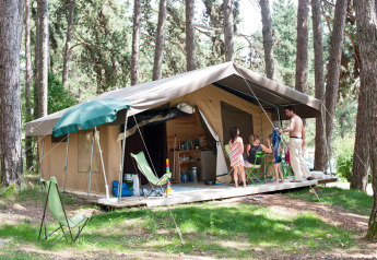 Familie nyder camping ved en safari telt Sweet på Huttopia Divonne Les Bains midt i skov i Frankrig.