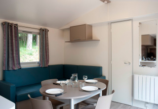 Zona pranzo nella Mobile home Vancouver a Huttopia Divonne Les Bains, Francia, con arredi moderni.