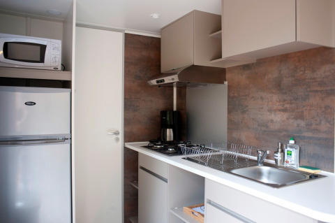 Cocina moderna con microondas, nevera, estufa, fregadero y escurridor en Mobile home Vancouver, Francia.