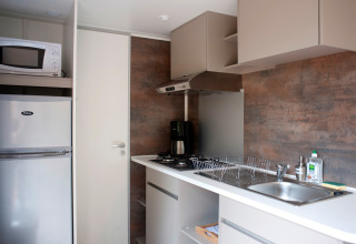 Cocina moderna con microondas, nevera, estufa, fregadero y escurridor en Mobile home Vancouver, Francia.