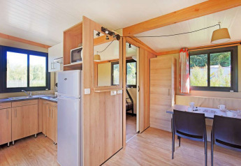 Vista interior de la Mobile home Vancouver en Huttopia Lac de la Siauve, Francia, con decoración moderna de madera y ventanas.