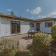 Wilbrink chalet ved Holiday park De Boshoek i Nederlandene, set udefra med have og udendørs siddeplads.