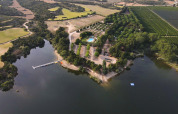 Luftfoto af TAIGA Lake Caspe feriepark i Aragón, Spanien, med sø, skov og swimmingpool.