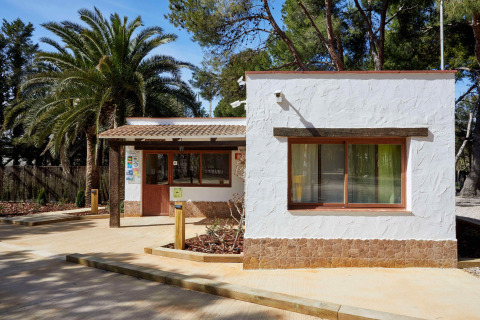 Edificio reception al TAIGA Lake Caspe, villaggio turistico in Aragona, Spagna, tra palme e natura.