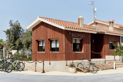 Edificio de recepción del parque vacacional TAIGA Delta de l'Ebre en Cataluña, España, con bicicletas afuera.