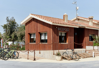 Edificio de recepción del parque vacacional TAIGA Delta de l'Ebre en Cataluña, España, con bicicletas afuera.