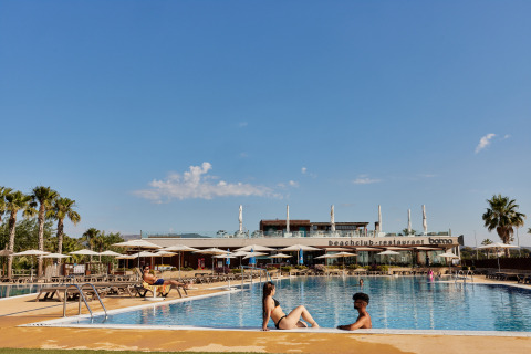 Piscina del parque vacacional TAIGA Delta de l'Ebre en Cataluña, España, con huéspedes relajándose al sol.
