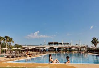 Ferieparkpool ved TAIGA Delta de l'Ebre i Catalonien, Spanien, med gæster der slapper af under blå himmel.