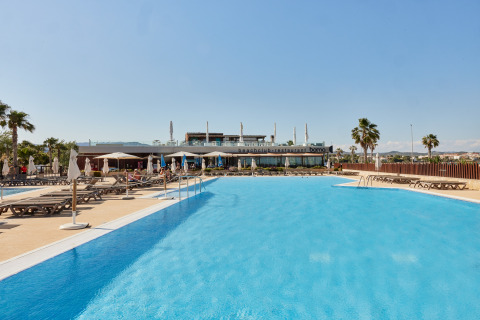 Außenpool mit Liegestühlen und Sonnenschirmen im TAIGA Delta de l’Ebre Ferienpark in Katalonien, Spanien.