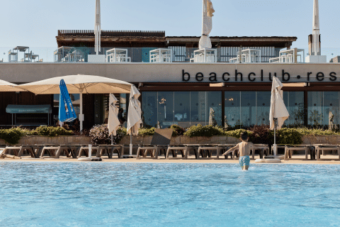 Dreng i badebukser går i pool foran beachclub resort ved TAIGA Delta de l'Ebre, Catalonien, Spanien.