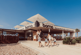Famille arrivant au restaurant Bama beachclub du parc de vacances TAIGA Delta de l'Ebre en Catalogne, Espagne.
