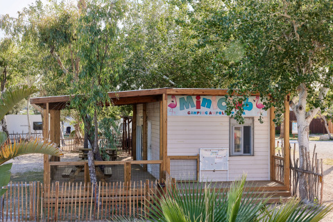 Houten Mini Club-huisje omringd door bomen in vakantiepark TAIGA Delta de l'Ebre, Catalonië, Spanje.