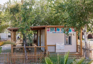 Træhus med skiltet 'Mini Club' omgivet af træer på TAIGA Delta de l'Ebre feriepark i Catalonien, Spanien.