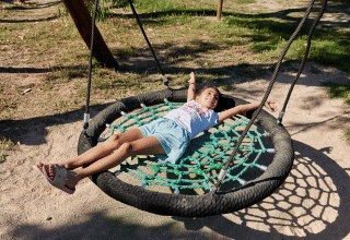 Un niño se relaja en un columpio en TAIGA Delta de l'Ebre, un parque vacacional en Cataluña, España.
