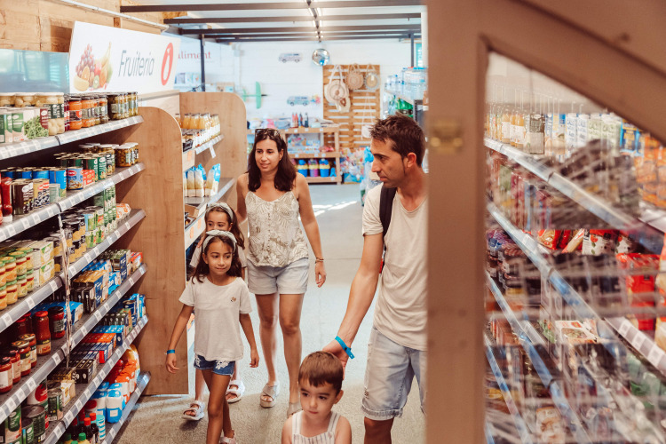 Gezin winkelt in de supermarkt van vakantiepark TAIGA Delta de l'Ebre in Catalonië, Spanje.