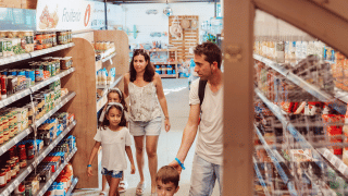 Familia de compras en el supermercado del parque vacacional TAIGA Delta de l'Ebre en Cataluña, España.
