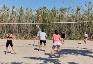 Menschen spielen Beachvolleyball im TAIGA Delta de l'Ebre Ferienpark in Katalonien, Spanien bei Sonnenschein.