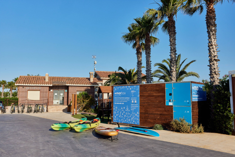 Bikes, kayaks, and palm trees outside TAIGA Delta de l'Ebre holiday park in Catalonia, Spain.