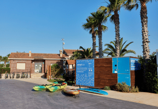 Vélos, kayaks et palmiers devant le parc de vacances TAIGA Delta de l'Ebre en Catalogne, Espagne.