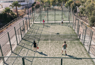 Fritidspark i Catalonien, Spanien med padeltennisbaner og gæster, der nyder en udendørs sportsaktivitet.