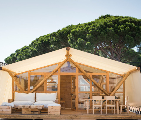 Luxuszelt im Ferienpark TAIGA Tarifa, Andalusien, Spanien, mit Holzveranda und moderner Einrichtung.