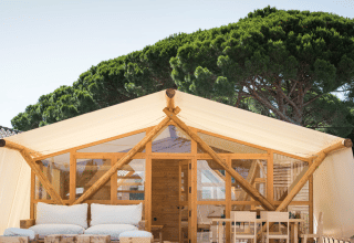 Luxe tent bij TAIGA Tarifa vakantiepark in Andalusië, Spanje, met houten meubilair en modern design.