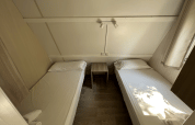 Two single beds in Bungalow Urbasa at Camping Etxarri, Spain, with nightstand and bright, modern decor.