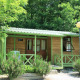 Et hyggeligt træbungalow ved navn Aratz, omgivet af grønne træer og en velplejet have foran.
