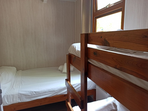 Cozy cabin room with bunk bed and single bed at Bungalow Aratz, Camping Etxarri, Spain.