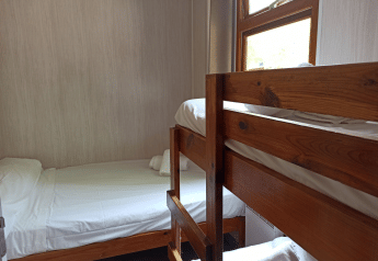 Camera accogliente con letto a castello e letto singolo nel Bungalow Aratz al Camping Etxarri, Spagna.