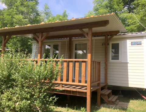 Foto van Mobile home Urederra, een gezellig huisje met houten veranda en omliggend groen.