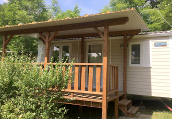 Foto van Mobile home Urederra, een gezellig huisje met houten veranda en omliggend groen.
