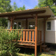 Et billede af Mobile home Urederra, en hyggelig hytte med træveranda omgivet af grønne planter.