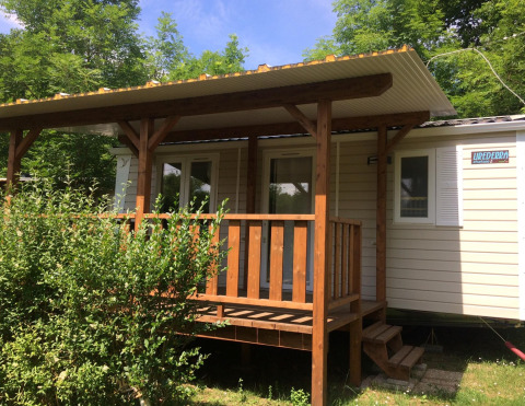 Afbeelding van Mobile home Urederra, een knusse blokhut met houten veranda en veel groen rondom.