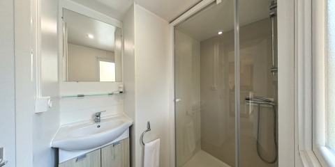 Baño de la Mobile home Urederra con ducha, lavabo, espejo y toalla en Camping Etxarri, España.