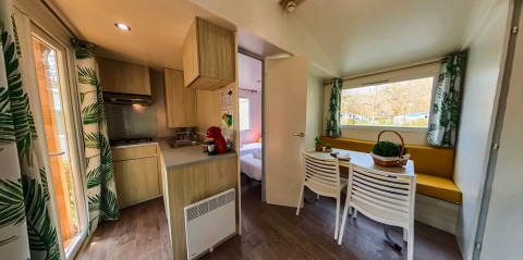 Interieur van Mobile home Urederra op Camping Etxarri in Spanje, met keuken, eethoek en grote ramen.