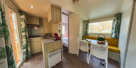 Interior of Mobile home Urederra at Camping Etxarri in Spain, with kitchen, dining area and large windows.