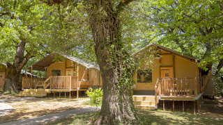 Safaritenten bij Glamping Haritza met houten veranda’s, omgeven door groen en een bosrijke natuur.