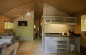 Interior of Glamping Haritza safari tent at Camping Etxarri, Spain, featuring a kitchen and living area.
