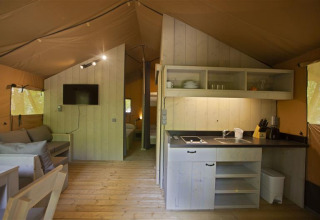 Interiør af Glamping Haritza safaritelt på Camping Etxarri i Spanien med køkken og opholdsområde.