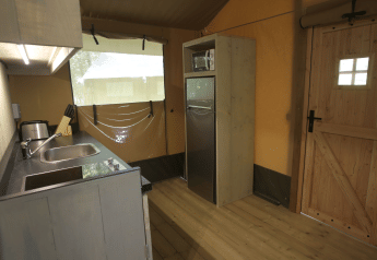 Kitchen area in Glamping Haritza safari tent at Camping Etxarri, Spain, featuring a sink, fridge, and microwave.