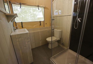 Badeværelse i et safari-telt på Glamping Haritza, Camping Etxarri i Spanien, med bruser, toilet og vask.