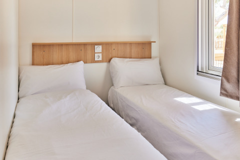 Dos camas individuales con sábanas blancas en una habitación luminosa, Bungalow Premium Agave, TAIGA Almeria Playa, España.