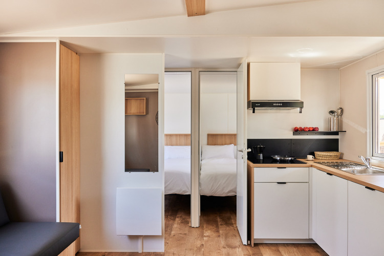 Modernes Küchen- und Schlafzimmerinterieur im Bungalow Premium Agave bei TAIGA Almeria Playa, Spanien.